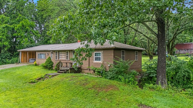 1215 Lanton Rd, West Plains, MO 65775 - view of front of house featuring dirt driveway, a front lawn, and a metal roof