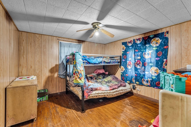 1215 Lanton Rd, West Plains, MO 65775 - bedroom with hardwood / wood-style floors, wooden walls, and ceiling fan