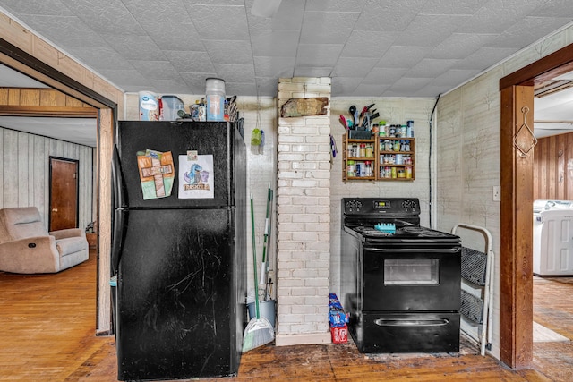 1215 Lanton Rd, West Plains, MO 65775 - kitchen with black appliances, washer / clothes dryer, wood-type flooring, and wooden walls
