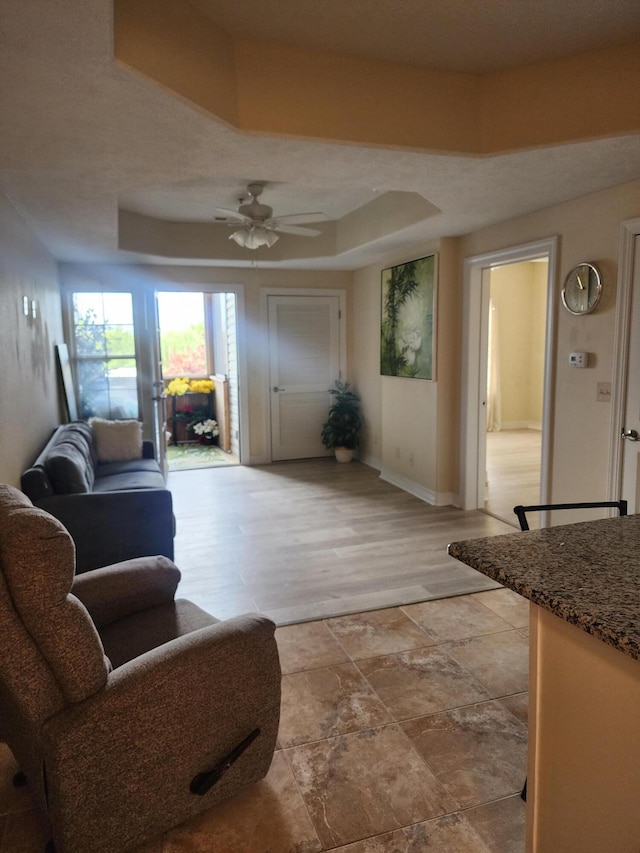 180 Grace Chapel Rd Unit 228, Blue Eye, MO 65611 - living room featuring ceiling fan, a raised ceiling, and light stone finish floors
