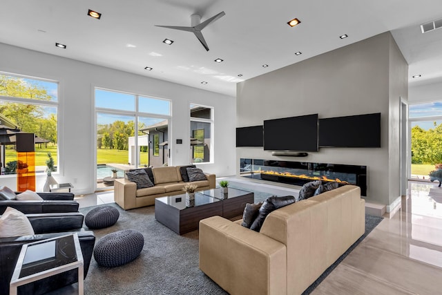 6298 E Summit View Dr, Springfield, MO 65809 - living room with ceiling fan, a glass covered fireplace, recessed lighting, and a high ceiling