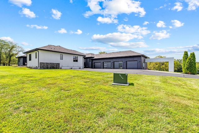 6298 E Summit View Dr, Springfield, MO 65809 - back of property featuring a lawn, a garage, and driveway