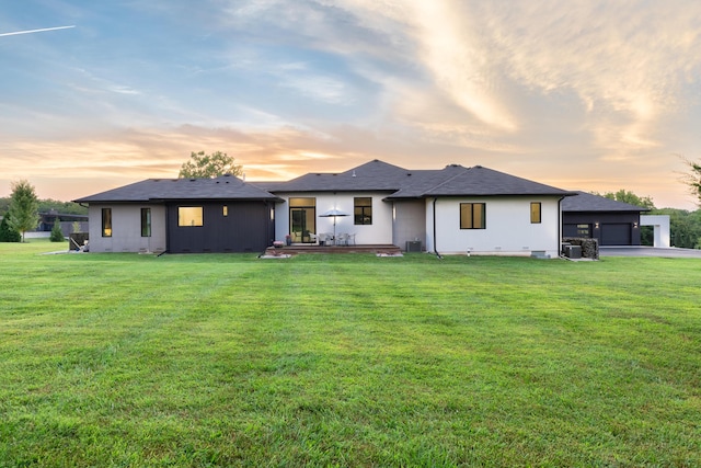 6298 E Summit View Dr, Springfield, MO 65809 - back of house at dusk with a yard and an attached garage