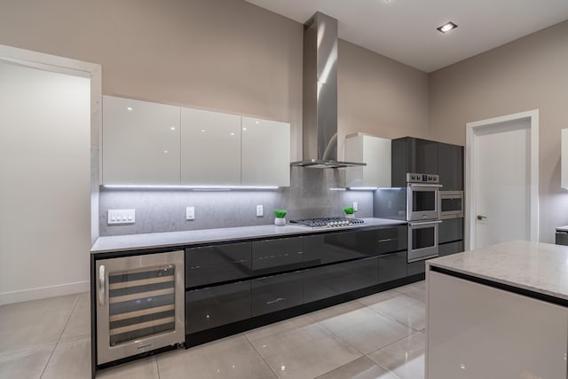6298 E Summit View Dr, Springfield, MO 65809 - kitchen featuring beverage cooler, modern cabinets, wall chimney exhaust hood, light tile patterned flooring, and backsplash