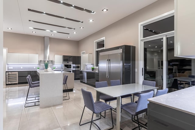 6298 E Summit View Dr, Springfield, MO 65809 - dining space with wine cooler, a towering ceiling, recessed lighting, and light tile patterned floors