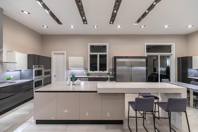 6298 E Summit View Dr, Springfield, MO 65809 - kitchen with stainless steel appliances, modern cabinets, a spacious island, recessed lighting, and decorative backsplash