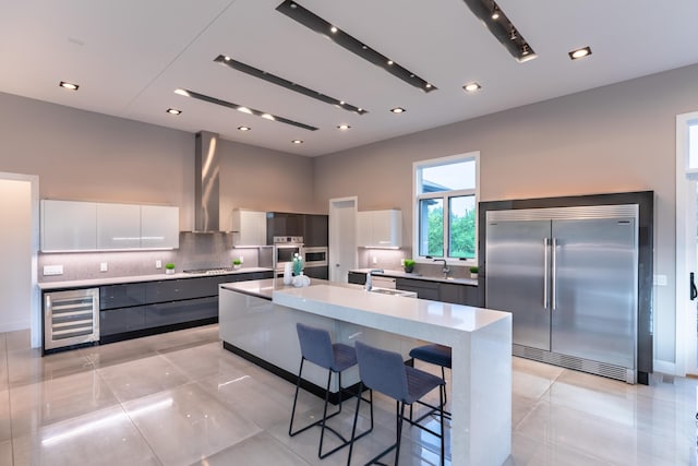 6298 E Summit View Dr, Springfield, MO 65809 - kitchen featuring stainless steel appliances, beverage cooler, modern cabinets, decorative backsplash, and a spacious island