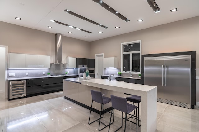6298 E Summit View Dr, Springfield, MO 65809 - kitchen with stainless steel appliances, wine cooler, modern cabinets, backsplash, and a towering ceiling