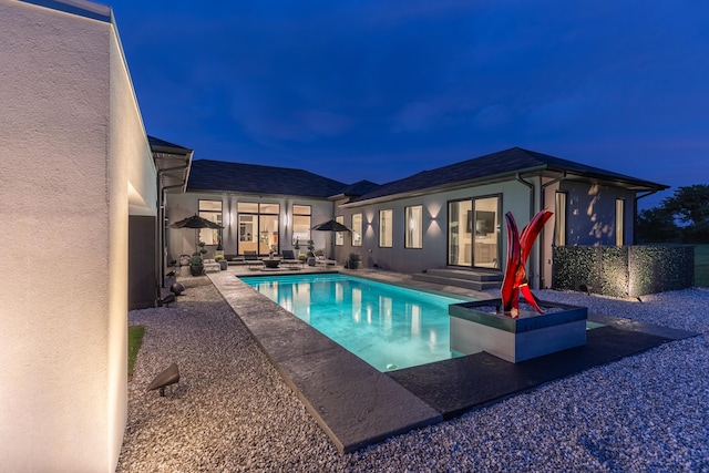 6298 E Summit View Dr, Springfield, MO 65809 - pool at night with an outdoor pool, a patio area, and an outbuilding