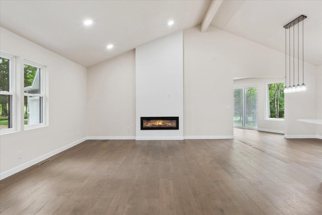 654 Rochester Rd, Sparta, MO 65753 - unfurnished living room featuring hardwood / wood-style flooring, beam ceiling, plenty of natural light, a glass covered fireplace, and high vaulted ceiling