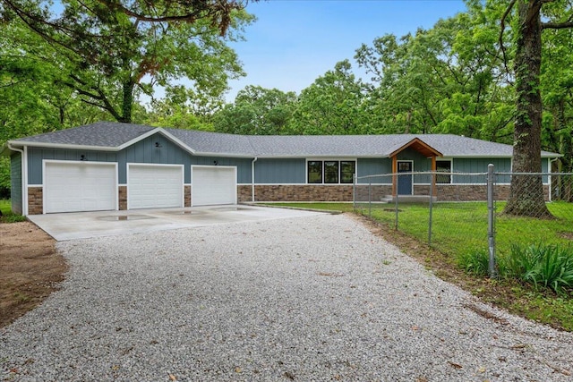 654 Rochester Rd, Sparta, MO 65753 - view of front facade with stone siding, driveway, a garage, a shingled roof, and board and batten siding