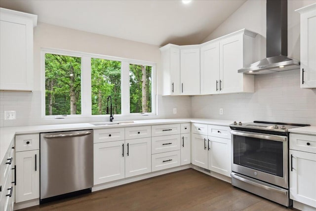 654 Rochester Rd, Sparta, MO 65753 - kitchen featuring wall chimney range hood, appliances with stainless steel finishes, dark wood-type flooring, light countertops, and backsplash