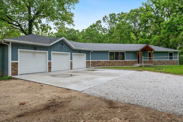 654 Rochester Rd, Sparta, MO 65753 - single story home featuring stone siding, concrete driveway, an attached garage, board and batten siding, and a shingled roof