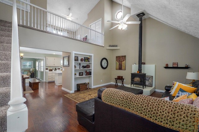 3711 W Farm Road 14, Brighton, MO 65617 - living area featuring a ceiling fan, a wood stove, high vaulted ceiling, dark wood-style floors, and a textured ceiling