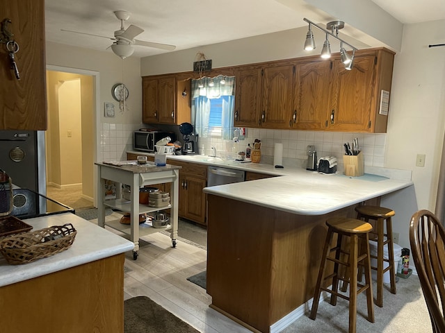 2105 Oakridge Dr, Ava, MO 65608 - kitchen featuring a peninsula, brown cabinetry, and light countertops