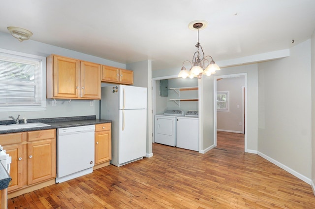 921 S Nettleton Ave, Springfield, MO 65806 - kitchen with white appliances, washing machine and clothes dryer, dark countertops, light wood finished floors, and a chandelier