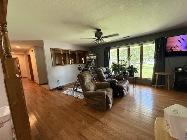 1301 W Blair Dr, Stockton, MO 65785 - living room with light wood-style flooring, a textured ceiling, and ceiling fan