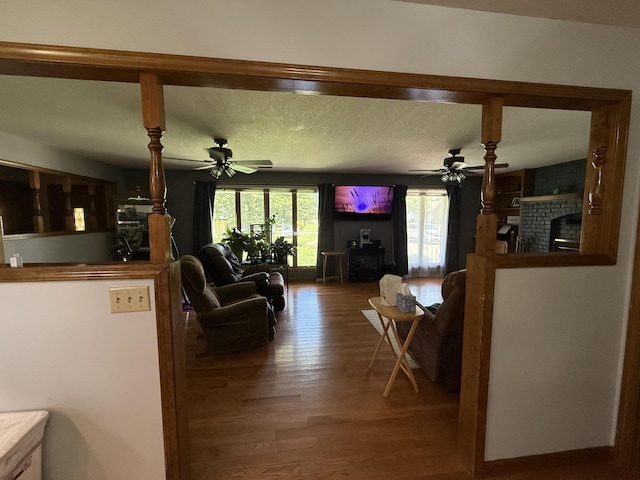 1301 W Blair Dr, Stockton, MO 65785 - living room featuring ceiling fan, wood finished floors, and a fireplace