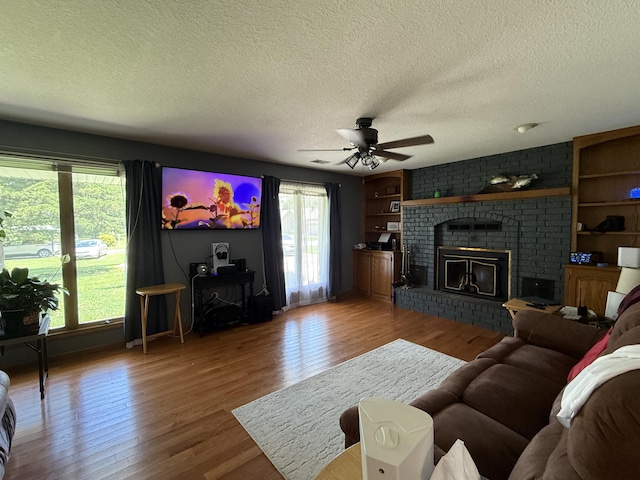1301 W Blair Dr, Stockton, MO 65785 - living room featuring healthy amount of natural light, a textured ceiling, wood finished floors, and ceiling fan