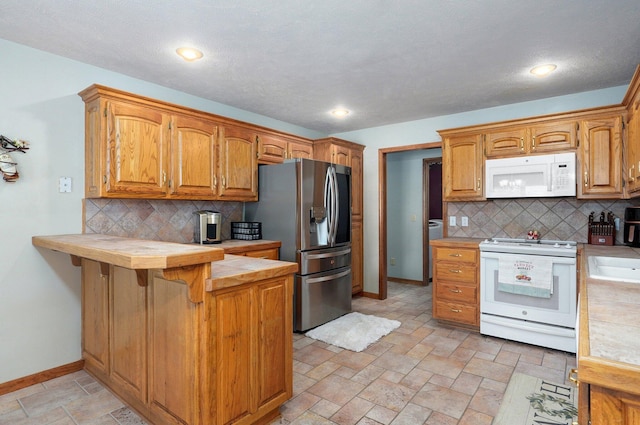 5150 S Dollison Ave, Springfield, MO 65810 - kitchen featuring white appliances, a peninsula, backsplash, and stone tile flooring