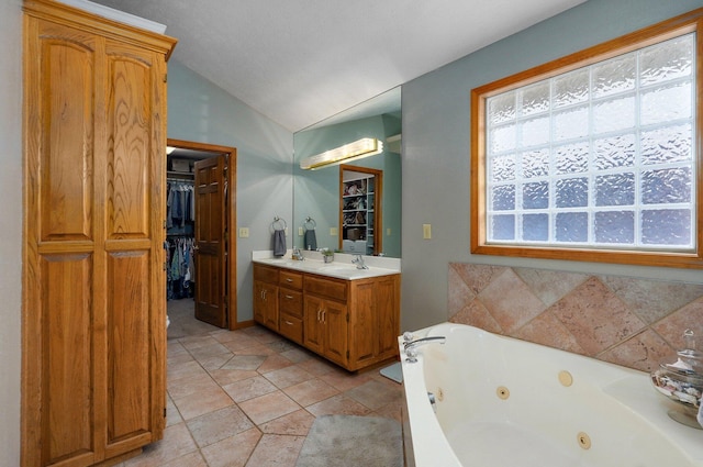 5150 S Dollison Ave, Springfield, MO 65810 - bathroom with vaulted ceiling, vanity, a tub with jets, and a spacious closet
