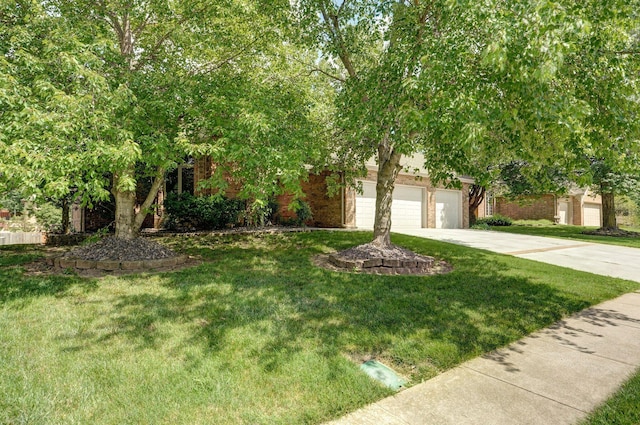 5150 S Dollison Ave, Springfield, MO 65810 - view of property hidden behind natural elements with concrete driveway, a front yard, and brick siding