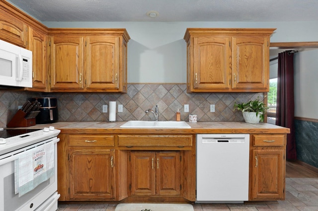 5150 S Dollison Ave, Springfield, MO 65810 - kitchen with white appliances, tile countertops, tasteful backsplash, and brown cabinetry