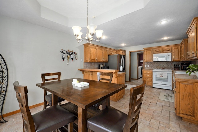 5150 S Dollison Ave, Springfield, MO 65810 - dining room with stone tile flooring, a chandelier, a tray ceiling, and recessed lighting