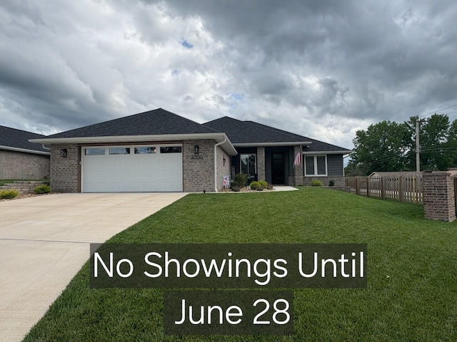2350 E Swallow St, Springfield, MO 65804 - view of front of home featuring a garage, concrete driveway, brick siding, and a shingled roof