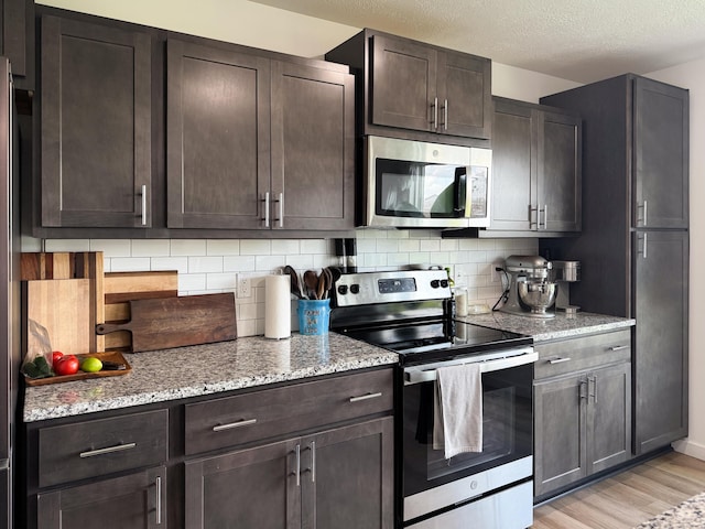 404 N Pine Leaf Rd, Nixa, MO 65714 - kitchen featuring appliances with stainless steel finishes, dark brown cabinetry, tasteful backsplash, and a textured ceiling