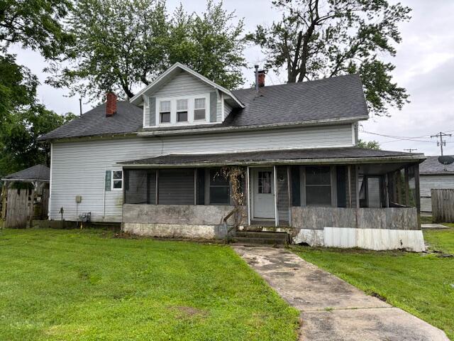 148 E Front St, Fordland, MO 65652 - view of front of home with a chimney, a front yard, and a sunroom