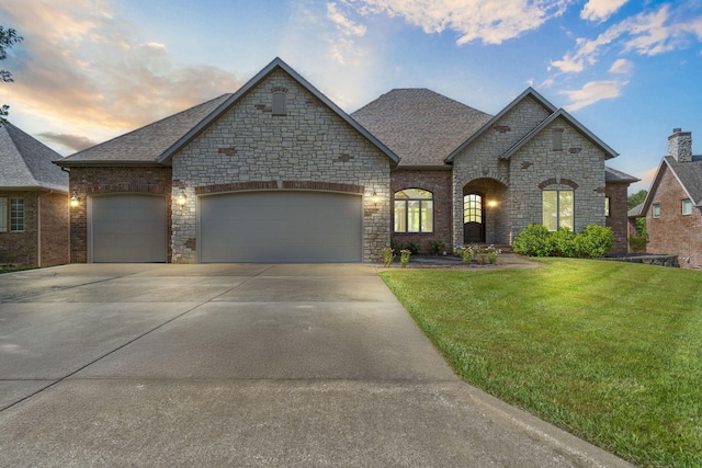 755 N Fallbrooke Ter, Springfield, MO 65802 - french provincial home featuring a lawn, concrete driveway, a garage, roof with shingles, and stone siding