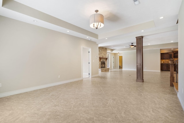 755 N Fallbrooke Ter, Springfield, MO 65802 - unfurnished living room with recessed lighting, a fireplace, ceiling fan, a raised ceiling, and ornate columns