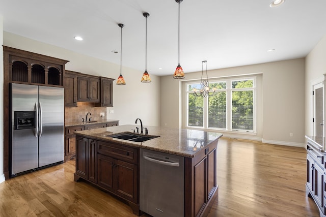 755 N Fallbrooke Ter, Springfield, MO 65802 - kitchen with stainless steel appliances, light wood finished floors, dark brown cabinetry, stone counters, and pendant lighting