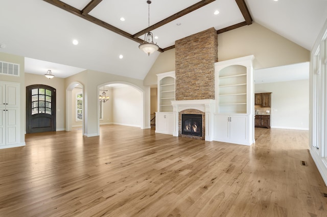 755 N Fallbrooke Ter, Springfield, MO 65802 - unfurnished living room with high vaulted ceiling, light wood-style flooring, arched walkways, a fireplace, and beam ceiling