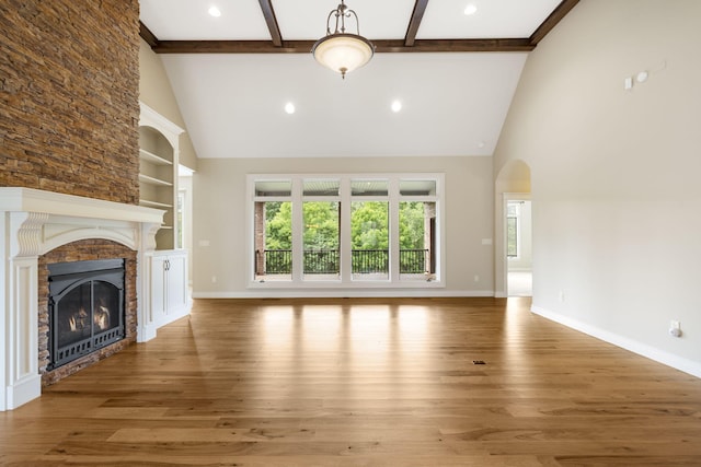 755 N Fallbrooke Ter, Springfield, MO 65802 - unfurnished living room featuring high vaulted ceiling, a glass covered fireplace, wood finished floors, beam ceiling, and arched walkways