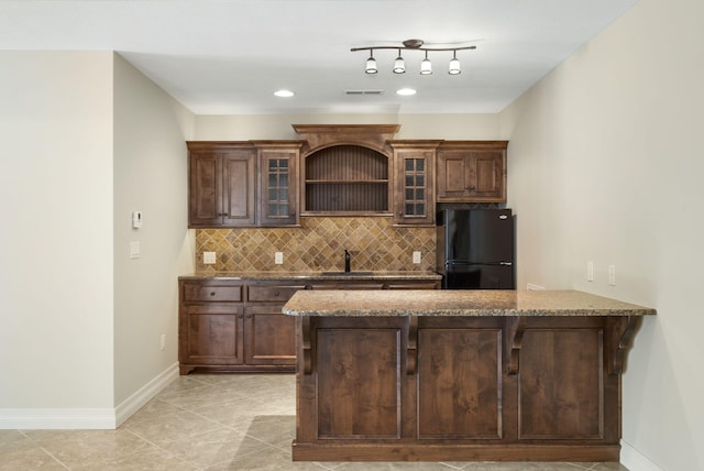 755 N Fallbrooke Ter, Springfield, MO 65802 - kitchen featuring freestanding refrigerator, backsplash, dark stone counters, a peninsula, and glass insert cabinets