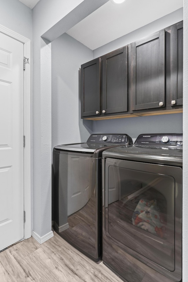 1917 Willoughby Rd, Clever, MO 65631 - laundry area featuring separate washer and dryer, light wood-style flooring, and cabinet space