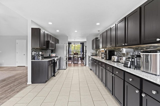 1917 Willoughby Rd, Clever, MO 65631 - kitchen with appliances with stainless steel finishes, decorative backsplash, recessed lighting, light stone countertops, and light tile patterned flooring