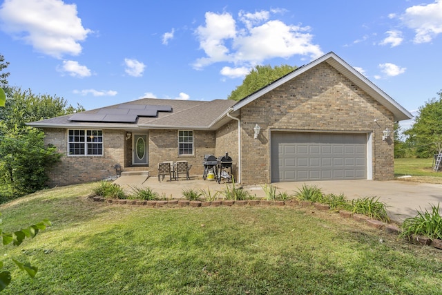 1917 Willoughby Rd, Clever, MO 65631 - ranch-style home featuring a front yard, concrete driveway, solar panels, and brick siding