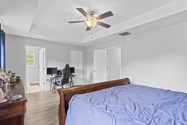1917 Willoughby Rd, Clever, MO 65631 - bedroom with a tray ceiling, wood finished floors, an office area, and a ceiling fan