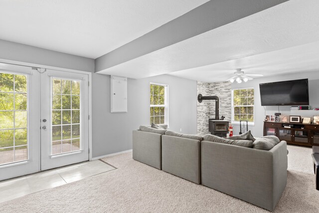 1917 Willoughby Rd, Clever, MO 65631 - living area featuring a wood stove, french doors, ceiling fan, carpet flooring, and tile patterned flooring