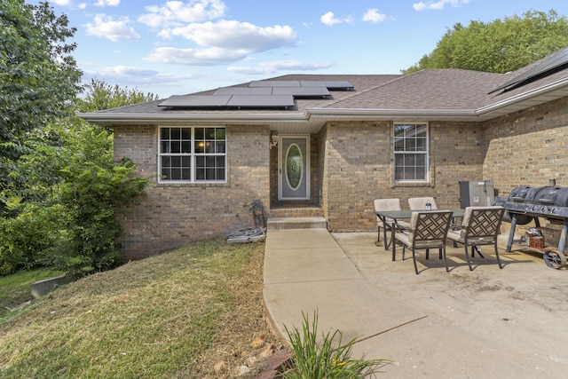 1917 Willoughby Rd, Clever, MO 65631 - property entrance featuring solar panels, roof with shingles, brick siding, and a patio area