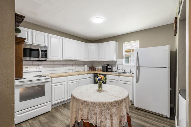 2116 N Main Ave, Springfield, MO 65803 - kitchen with white appliances, tasteful backsplash, white cabinetry, wood finished floors, and light countertops