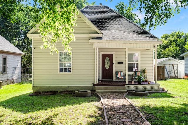 2116 N Main Ave, Springfield, MO 65803 - view of front of house with a storage unit, a wooden deck, and roof with shingles