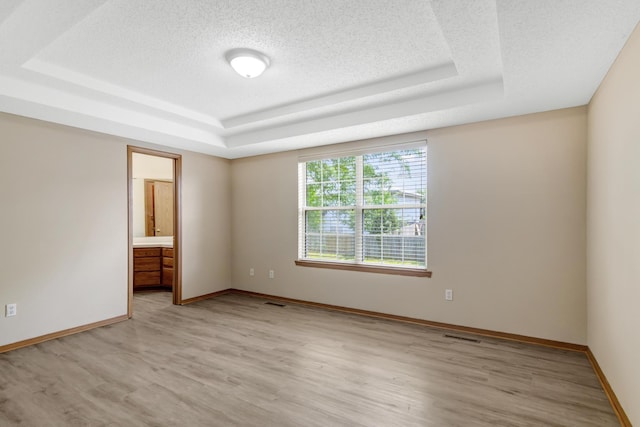 5590 S Aaron Ave, Springfield, MO 65810 - spare room featuring a raised ceiling, light wood-style flooring, and a textured ceiling