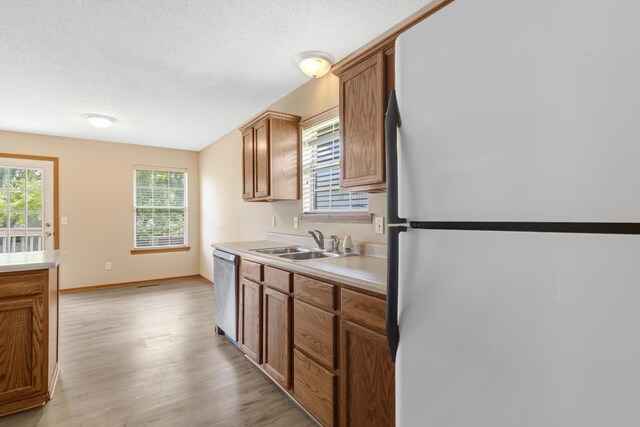 5590 S Aaron Ave, Springfield, MO 65810 - kitchen with freestanding refrigerator, dishwasher, healthy amount of natural light, light wood-style flooring, and a textured ceiling