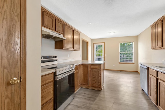 5590 S Aaron Ave, Springfield, MO 65810 - kitchen with appliances with stainless steel finishes, under cabinet range hood, light wood-type flooring, light countertops, and a peninsula