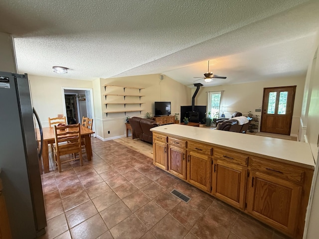 16051 Mo 142, Thayer, MO 65791 - kitchen featuring freestanding refrigerator, a wood stove, open floor plan, light countertops, and brown cabinets