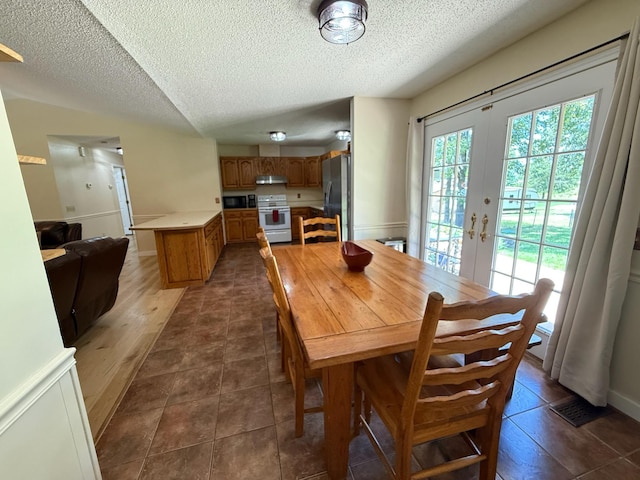 16051 Mo 142, Thayer, MO 65791 - dining area with a textured ceiling, french doors, and dark tile patterned flooring